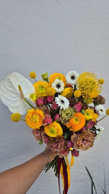 Ramo de flor tropical con anthurium blanco, ranúnculos y craspedia